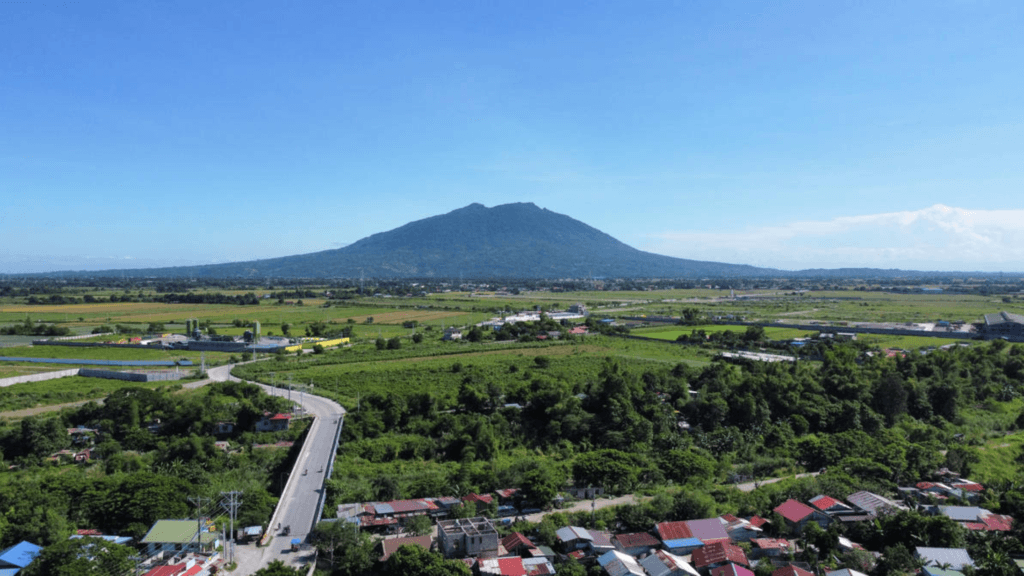 Aerial landscape of rural Pampanga with farms, houses, and Mount Arayat in the background.