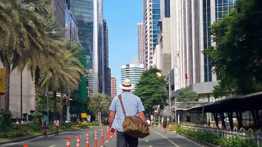 Foreign man walking along a BGC street while exploring nearby properties.