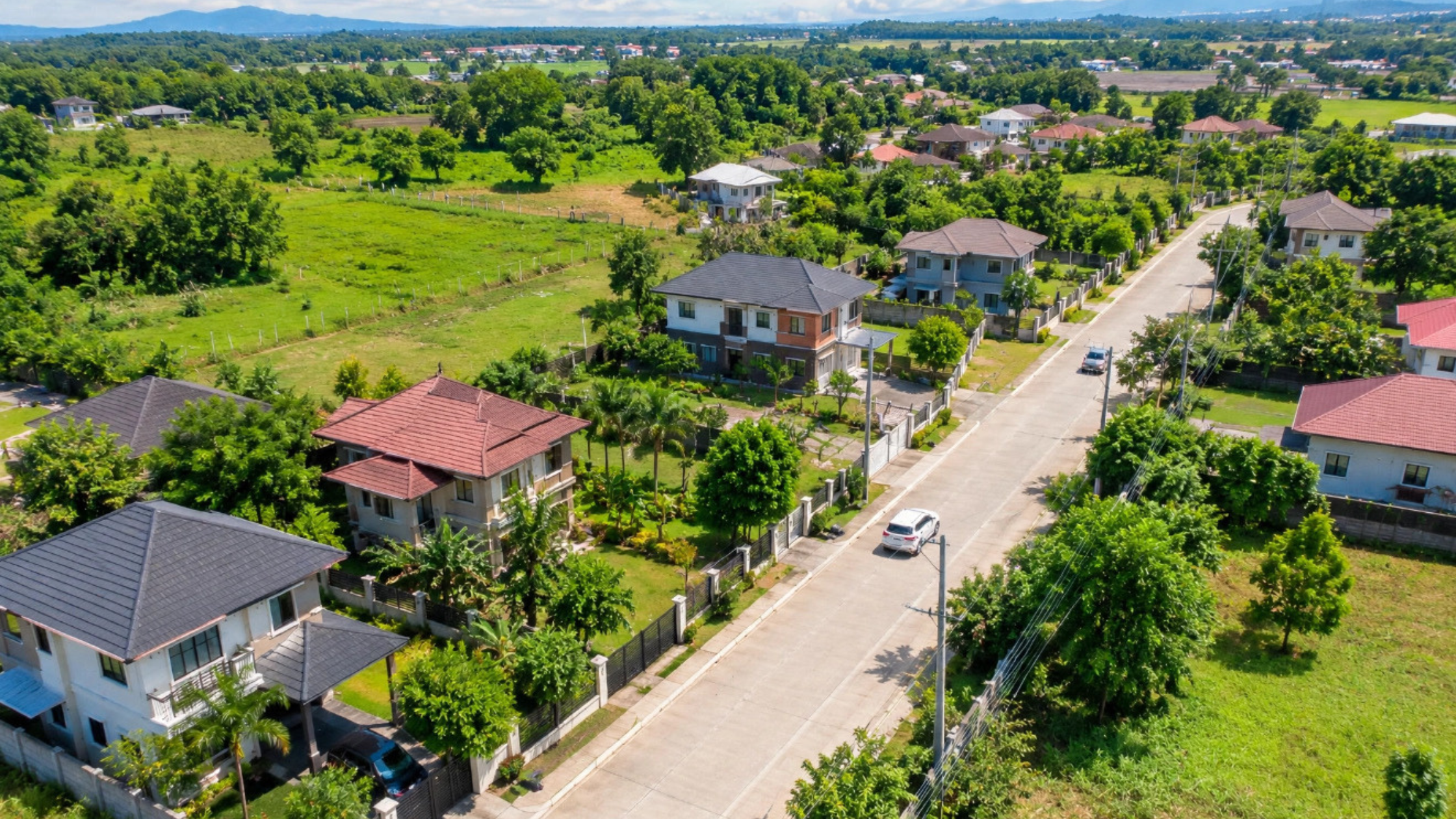Cavite residential neighborhood with paved road, houses, utility poles, and greenery